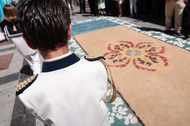 Bambini vestiti per la prima comunione durante la processione del Corpus Christi con tappeti stradali