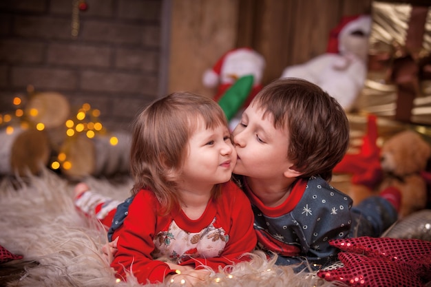 Bambini vicino all'albero di Natale con doni