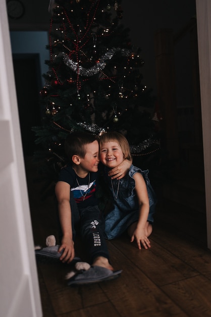 bambini vicino all'albero di natale