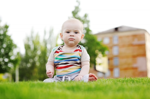 Bambino a piedi nudi seduto sull&#39;erba