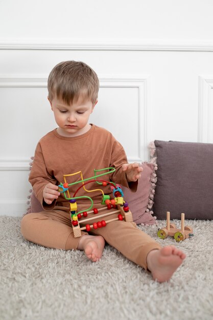 Bambino a tutto campo che gioca con il giocattolo educativo