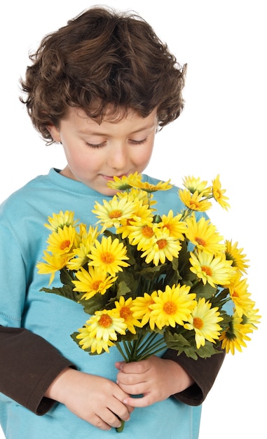 Bambino adorabile con i fiori sopra priorità bassa bianca