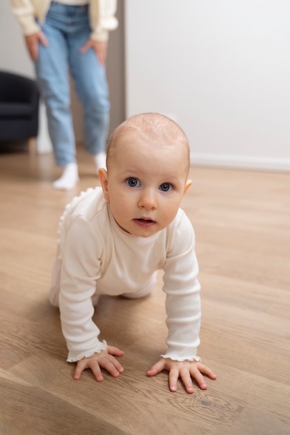 Bambino adorabile dell'angolo alto che striscia sul pavimento