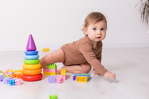 bambino adorabile in camicia marrone che gioca con giocattoli carta banner spazio per il testo