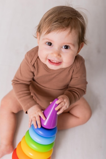 bambino adorabile in camicia marrone che gioca con giocattoli carta banner spazio per il testo