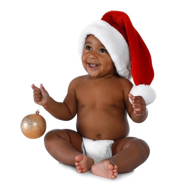 Bambino afroamericano sveglio che porta il cappello della Santa con la decorazione di Natale su priorità bassa bianca