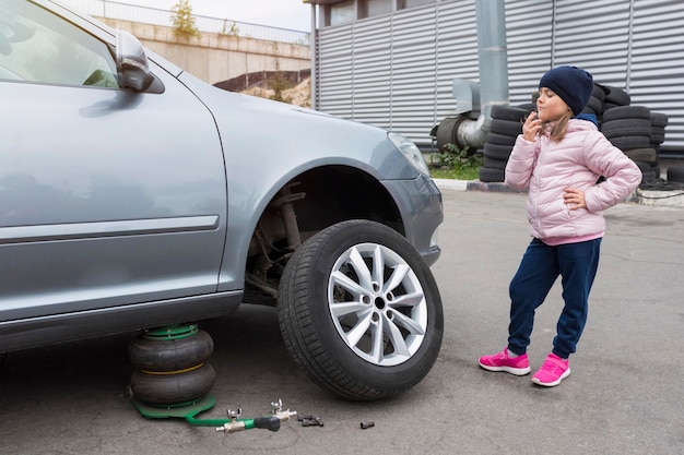 Bambino al servizio di auto Sostituzione delle ruote di un'auto Servizio di riparazione