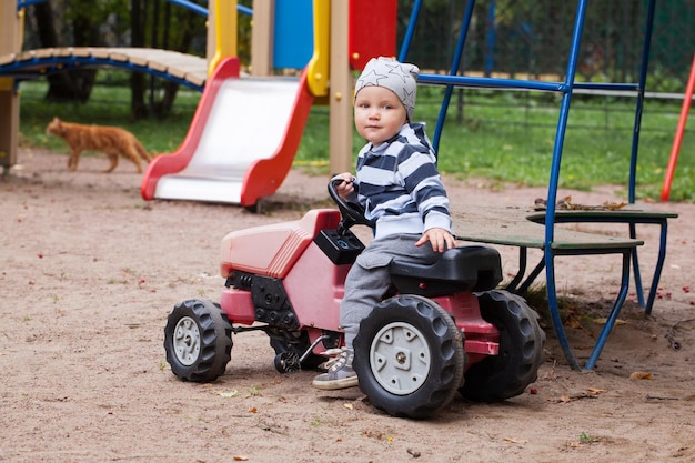 Bambino alla guida di un giocattolo per auto nel parco giochi