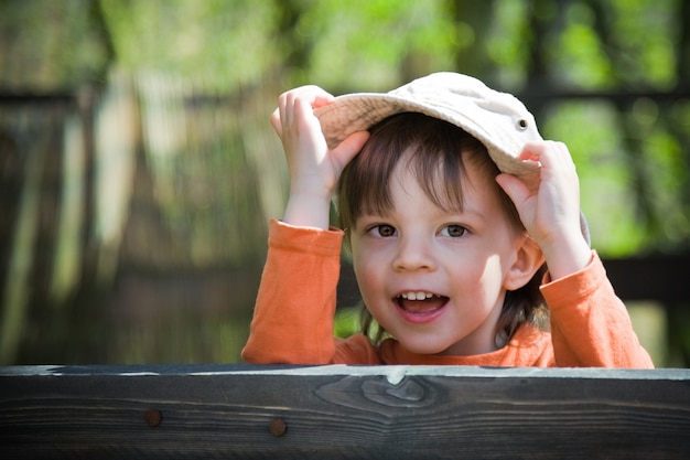 Bambino allegro che tiene il suo cappello