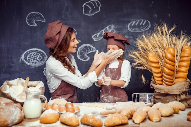 Bambino allegro con la madre che produce pasta