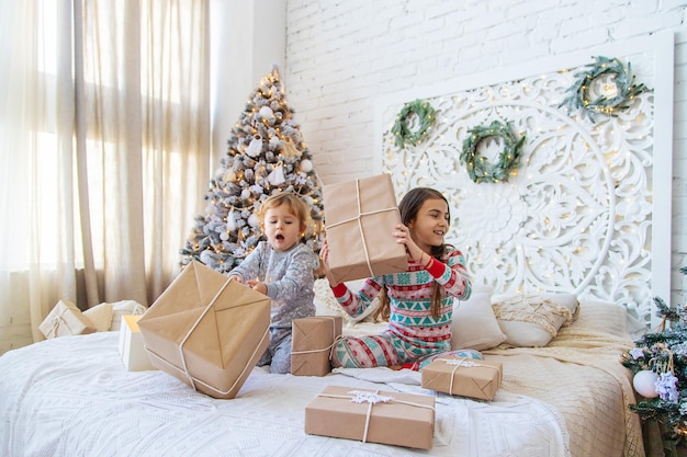 Bambino aperto regali di Natale sotto l'albero Messa a fuoco selettiva