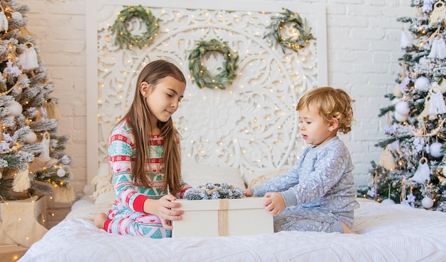 Bambino aperto regali di Natale sotto l'albero Messa a fuoco selettiva