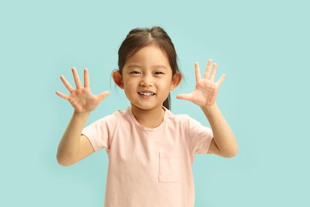 Bambino asiatico celebra con il gesto HighFive giovane esuberante irradia felicità su blu isolato