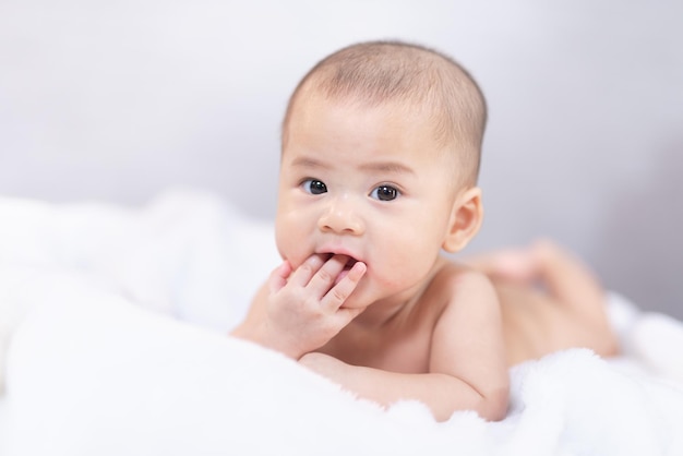 Bambino asiatico che dorme sul letto Illuminazione dello studio della neonata del ritratto sul letto di pelliccia Concetto di famiglia del bambino