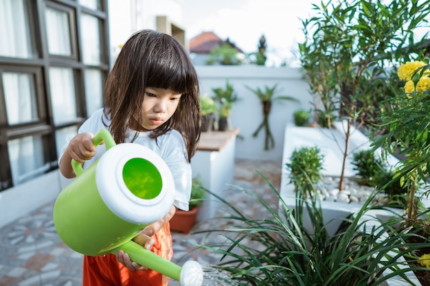 Bambino asiatico che fa il giardinaggio a casa