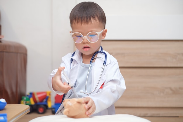 Bambino asiatico che gioca al dottore a casa