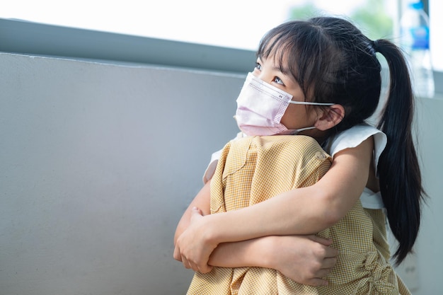 Bambino asiatico che indossa la maschera a casa