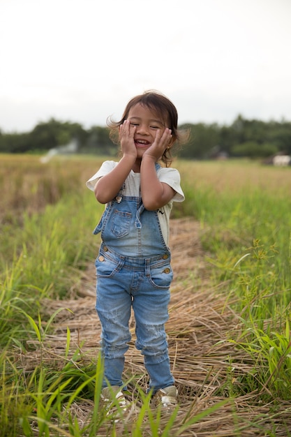 Bambino asiatico che sorride alla macchina fotografica in risone