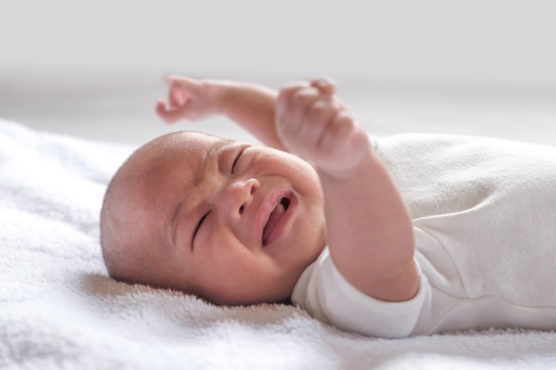 Bambino asiatico di 1 mese che piange a letto