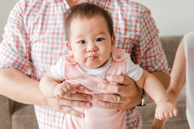 Bambino asiatico sveglio che si leva in piedi in su