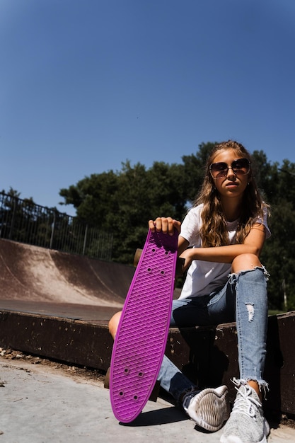 Bambino attivo con penny board seduto su skate rampa sportiva Stile di vita sportivo estremo Pubblicità creativa per negozio sportivo per bambini