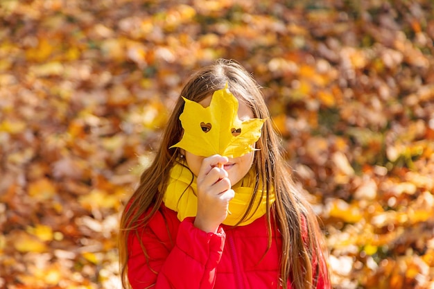 Bambino autunnale nel parco con foglie gialle Messa a fuoco selettiva Kid