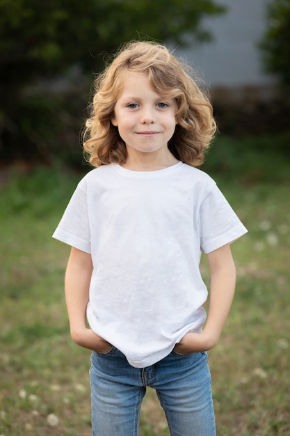 Bambino biondo con i capelli lunghi all'aperto