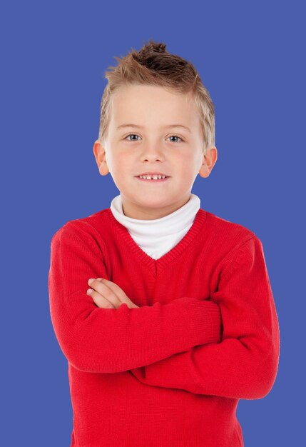Bambino biondo con maglia rossa isolata su sfondo blu