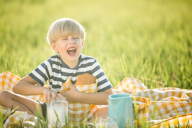 Bambino carino bere latte. Ragazzo adorabile che mangia pane