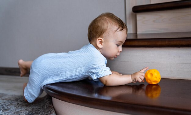 Bambino carino che gioca con la palla sulle scale Bambino che gioca con il giocattolo colorato Foyer e interni del soggiorno Sicurezza domestica per i bambini