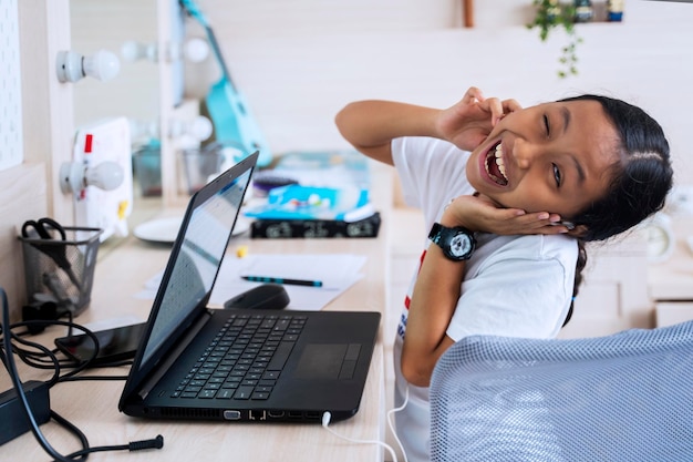 Bambino carino che impara con auricolare e laptop