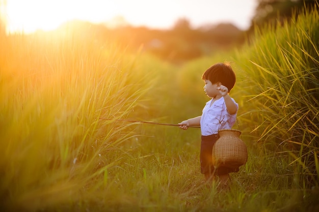 bambino carino che pesca nel campo