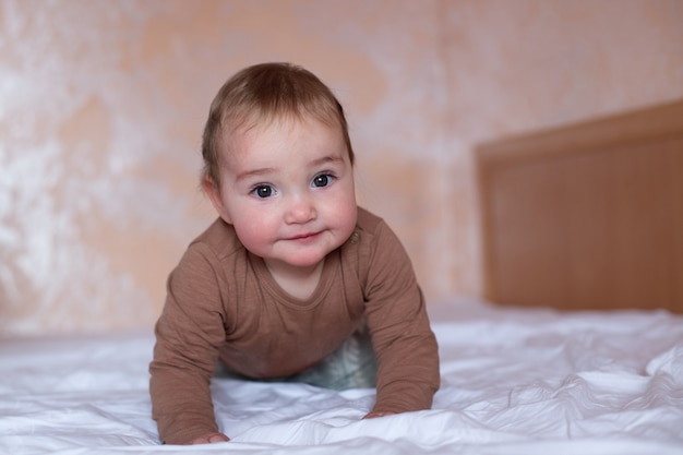 Bambino carino che striscia sul letto