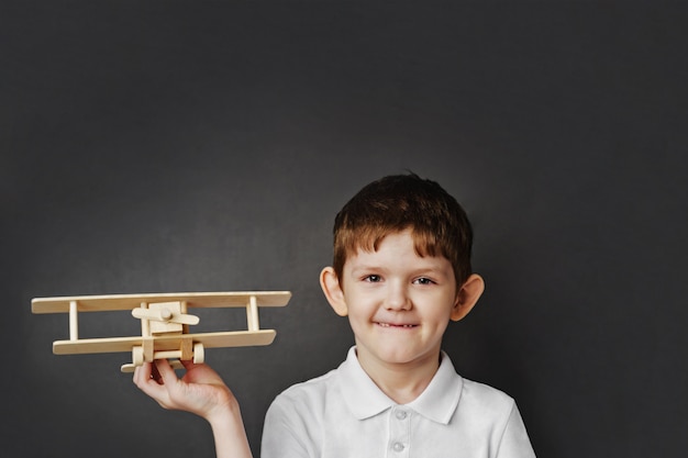 Bambino carino con aeroplano in legno