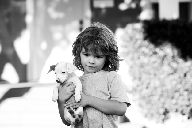 Bambino carino e cucciolo che giocano fuori. Cura degli animali, cucciolo.