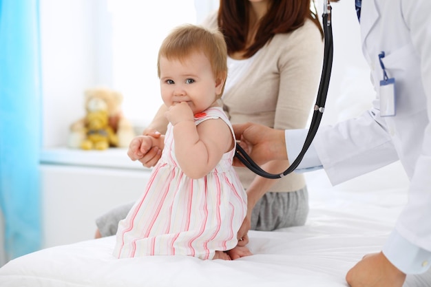 Bambino carino felice con sua madre all'esame di salute presso l'ufficio del medico