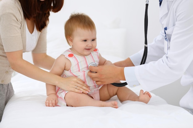 Bambino carino felice con sua madre all'esame di salute presso l'ufficio del medico