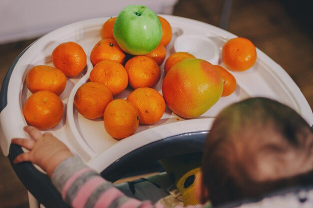 Bambino carino seduto accanto alla frutta