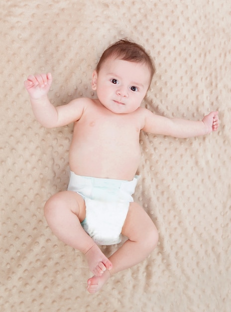 Bambino carino su una coperta marrone