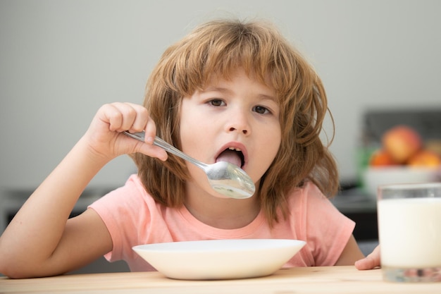 Bambino caucasico bambino che mangia una zuppa sana in cucina nutrizione del bambino