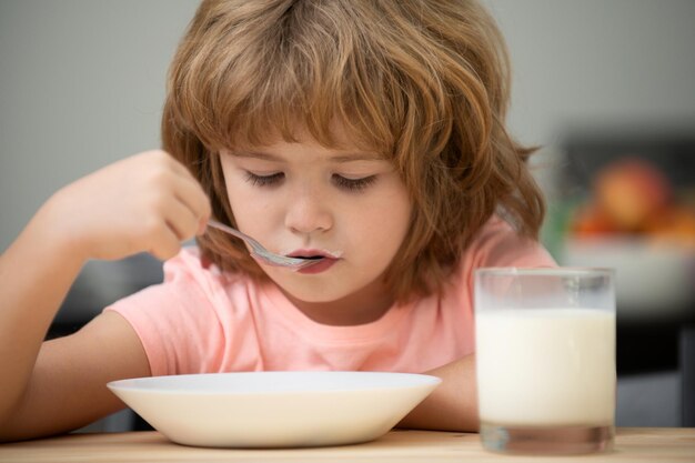 Bambino caucasico bambino che mangia una zuppa sana in cucina