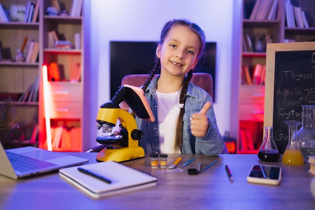 Bambino caucasico in abbigliamento casual studia facendo scienze la sera a casa