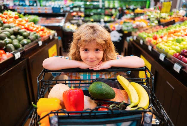 Bambino che acquista nel supermercato cibo sano per bambini bambino nel supermercato acquista verdure