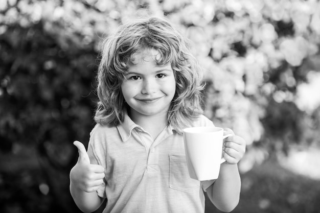 Bambino che beve tè o acqua nel giardino sul retro Curare i bambini e proteggere l'immunità dal virus stagionale concetto di salute dei bambini