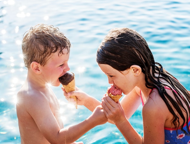 Bambino che condivide un gelato a bordo piscina