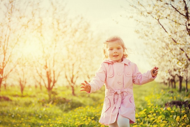 Bambino che corre all'aperto alberi in fiore.