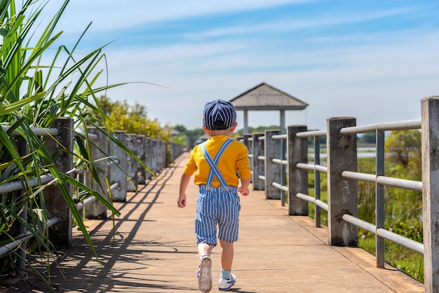 Bambino che corre sul ponte in natura.