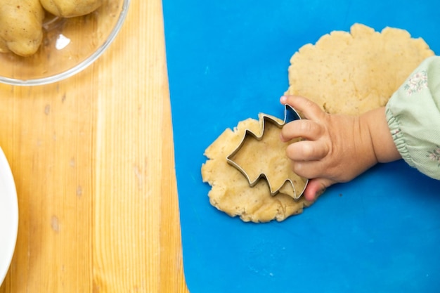 Bambino che crea forme con la pasta da gioco usando il mattarello