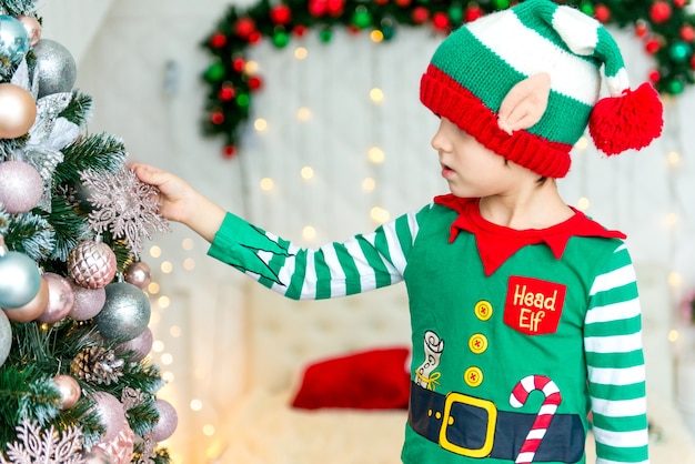 Bambino che decora l'albero di Natale a casa