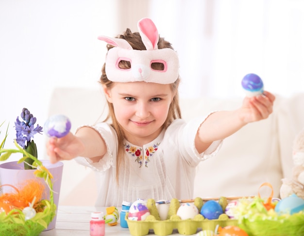 Bambino che dipinge alcune uova per Pasqua